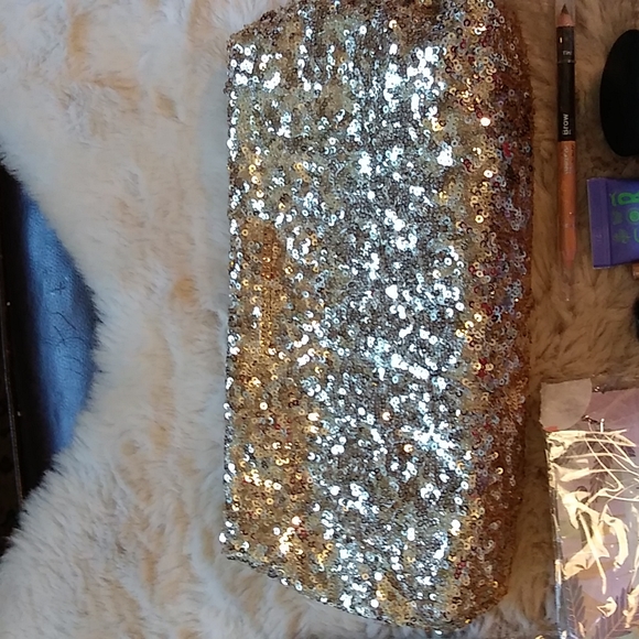 Gold Victoria's secret bag filled with a variety of beauty products. - Picture 3 of 13